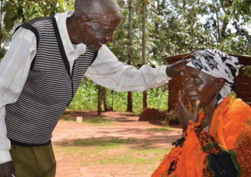 Bernard (left) was once blind from cataracts. Today he regularly walks great distances to check on rural families to identify eye injuries, cataracts and other eye issues.