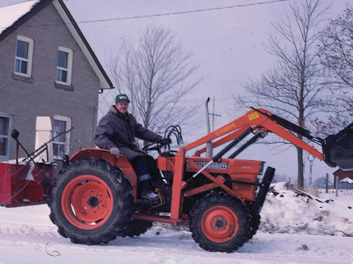 Roland with his tractor. He used it to rescue stuck cars during snowstorms, in exchange for donations to Operation Eyesight.