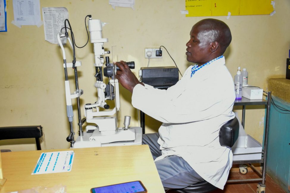 An optometrist works with a slip lamp