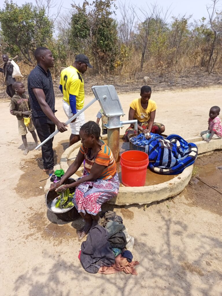 Women wash clothing at the newly-rehabilitated water borehole in the village of Lukanda B, Zambia.