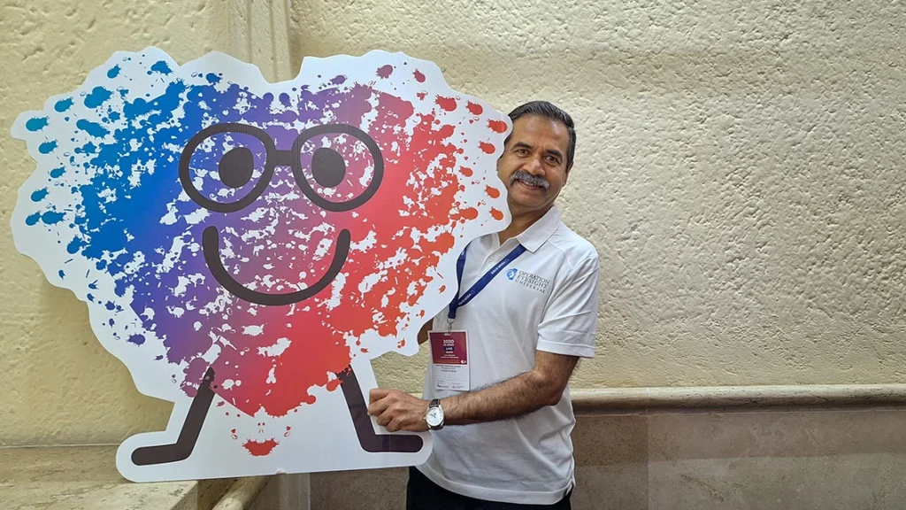 A man holds a cardboard mascot image.